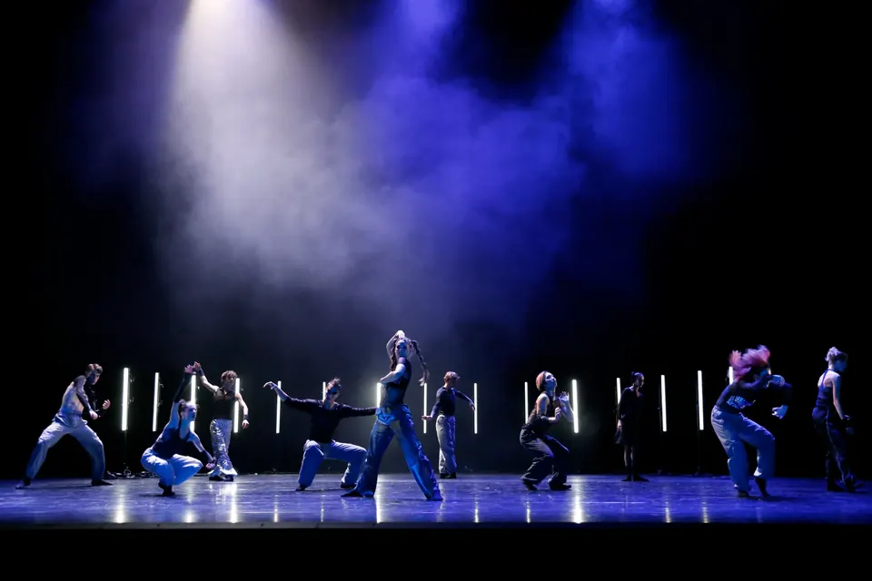 Ballett Chemnitz ensemble performing HERE WE STAND beneath blue stage lights