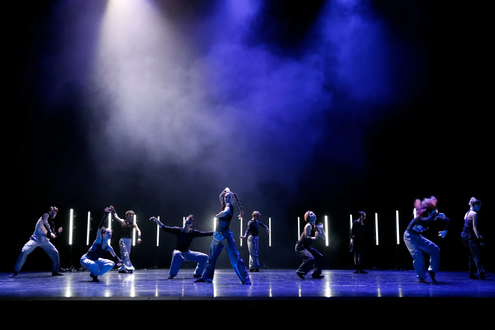 Ballett Chemnitz ensemble performing HERE WE STAND beneath blue stage lights