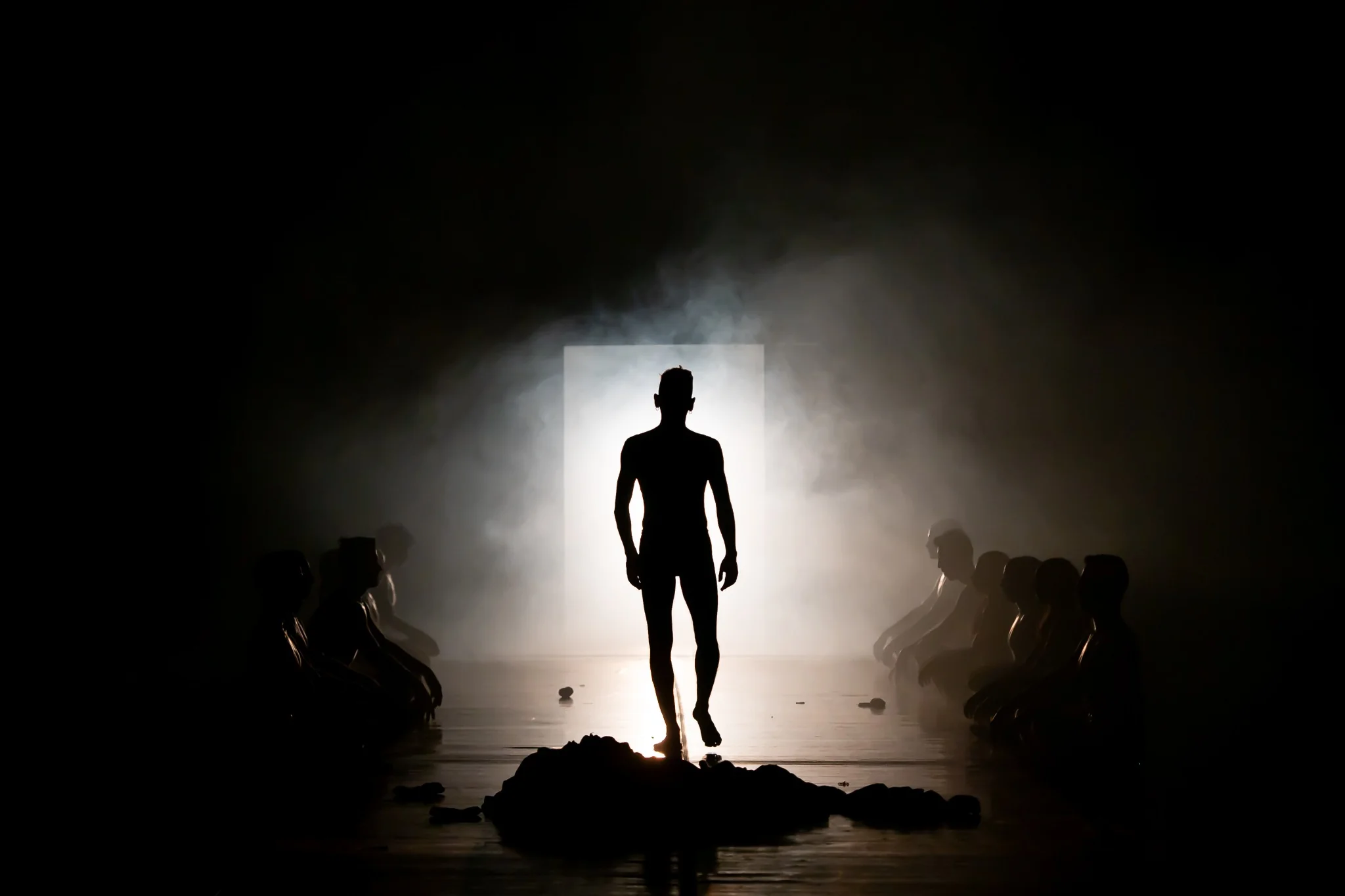 A silhouetted dancer emerging from a bright doorway in Rabbit Hole